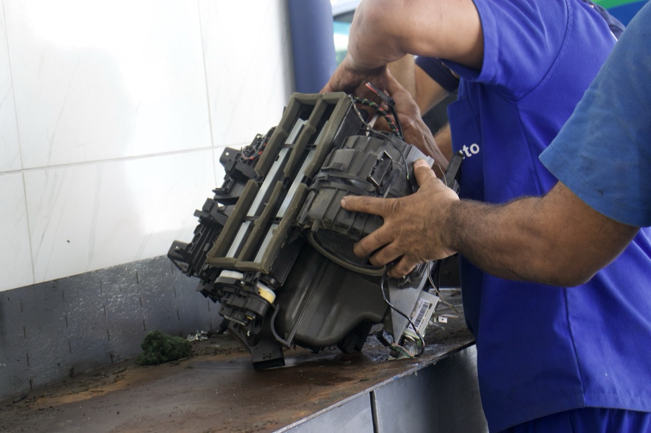 Técnico da Friauto trabalhando em um compressor de ar-condicionado